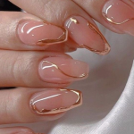 unha em gel nude com detalhe dourados transversais